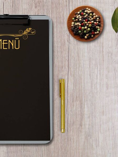 Une plaque sur laquelle est écrit menu à côté d'un stylo