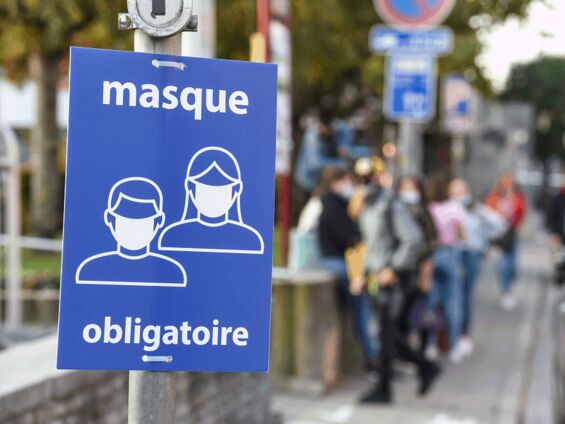 Une affiche qui explique que le port du masque est obligatoire est posée sur un poteau dans la ville