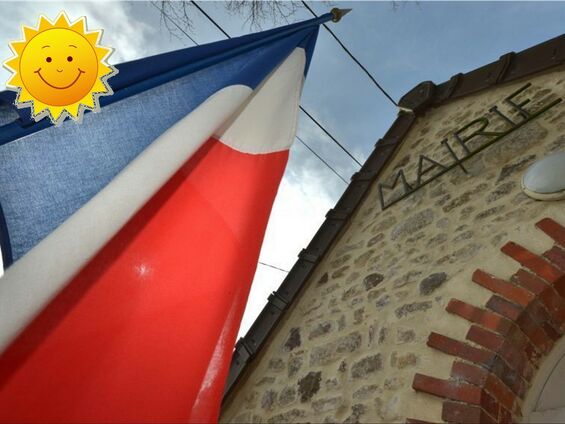 Le drapeau Français qui flotte sur le devant de la Mairie avec un rayon de soleil