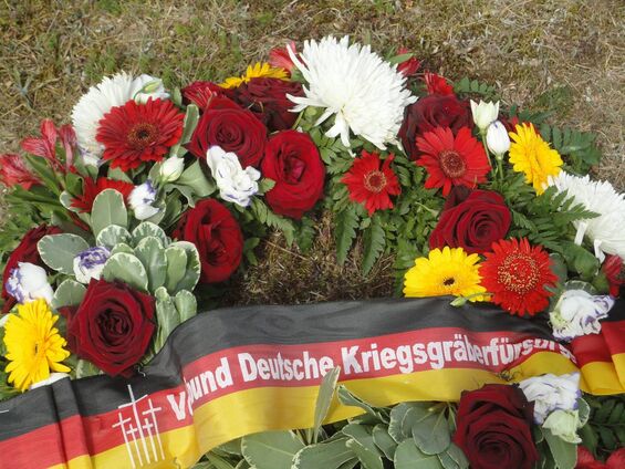 Gerbe de fleurs sur lequel est fixé un bandeau allemand